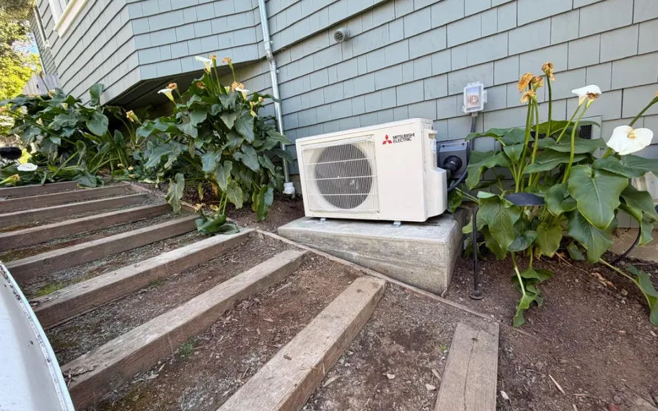 Outdoor heat pump beside garden steps