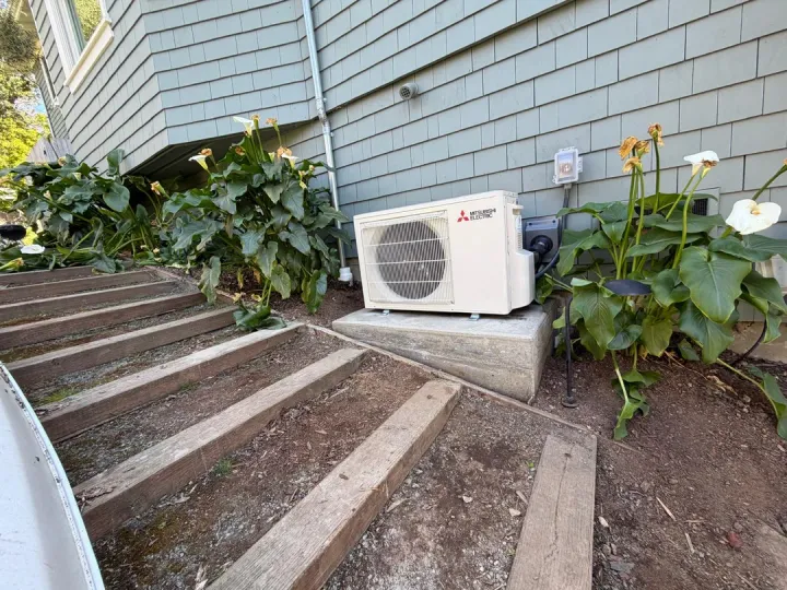 Outdoor heat pump beside garden steps